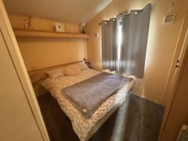 A bedroom with a bed and curtains at 29 Laburnham Court in Fleetwood