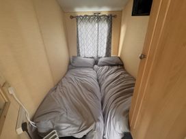 A bedroom with two beds and curtains at 29 Laburnham Court in Fleetwood