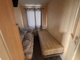 A bedroom with beds and curtains at 29 Laburnham Court in Fleetwood