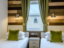 A bedroom with two beds and a window at Elsham Lodge in Louth