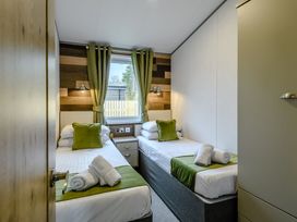 A bedroom with two beds and a window at Elsham Lodge in Louth