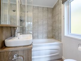 A bathroom with a bathtub, sink, and shower at Elsham Lodge in Louth