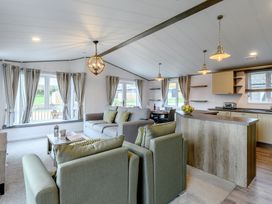 A living room with a sofa and kitchen unit at Elsham Lodge in Louth