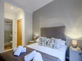 A bedroom with a bed and bathroom access at Stamford Spa (Pet) in Louth