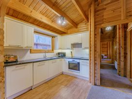 A kitchen with appliances and wooden cabinetry at Cedar Lodge (Pet) in Louth