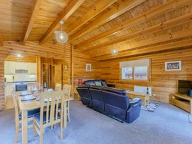 A living room with a dining table and sofa at Cedar Lodge (Pet) in Louth