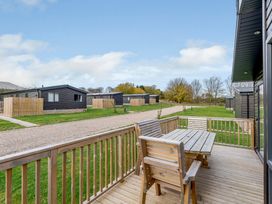 A deck area with a table and chairs at Elsham Lodge (Pet) Louth