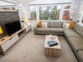 A living room with a sofa and television at Woodland View