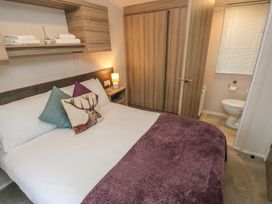 A bedroom with a bed and a bathroom at Woodland View