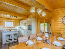 A kitchen with a dining area and bar stools at Hazel Lodge in Louth