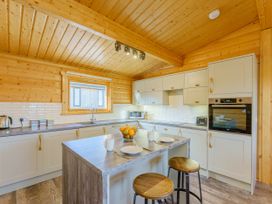 A kitchen with a counter, sink and stools at Hazel Lodge in Louth