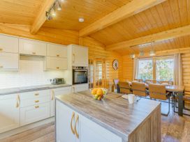 A kitchen with cabinets, countertop, and dining area at Hazel Lodge in Louth