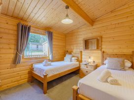 A bedroom with two beds and a window at Hazel Lodge in Louth