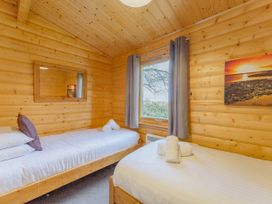 A bedroom with two beds and a window at Hazel Lodge in Louth