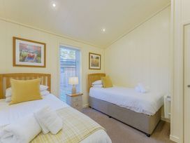 A bedroom with two beds and a lamp at Retreat Lodge 4 in Louth