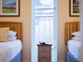 A bedroom with two beds and a side table at Retreat Lodge 4 in Louth