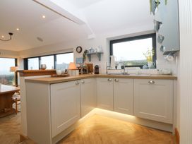 A kitchen with cabinets and a sink at Bryn Mor Cottage in Mynytho near Llanbedrog