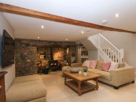 A living room with a sofa, coffee table and fireplace at Bryn Mor Cottage in Mynytho near Llanbedrog