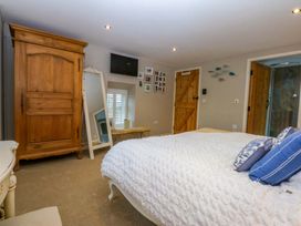 A bedroom with a bed and wardrobe at Bryn Mor Cottage Mynytho near Llanbedrog