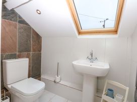 A bathroom with a toilet and sink at Bryn Mor Cottage Mynytho near Llanbedrog