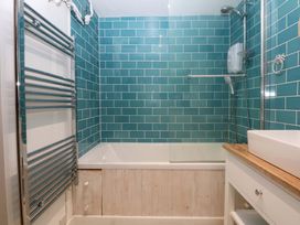 A bathroom with a bathtub and shower at Bryn Mor Cottage in Mynytho near Llanbedrog
