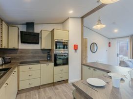 A kitchen with cabinets, oven, and stove at Brayford Lodge Spa in Louth
