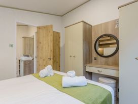 A bedroom with a bed and mirror at Brayford Lodge Spa in Louth