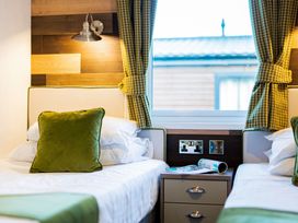 A bedroom with two beds and a nightstand at Brayford Lodge Spa in Louth