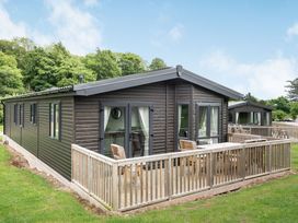 A lodge with decking and chairs at Brayford Lodge Spa in Louth
