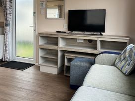 A living room with a television and sofa at New Caravan