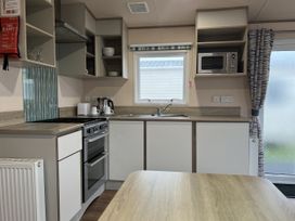 A kitchen with stove and microwave at New Caravan