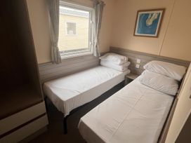 A bedroom with two single beds and a window at New Caravan