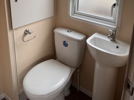A bathroom with a toilet and sink at New Caravan