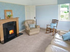 A living room with a fireplace and a rocking chair at Priory View in Ulverston