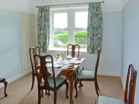 A dining room with a table set for dinner at Priory View in Ulverston