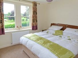 A bedroom with a bed and windows at Priory View Ulverston