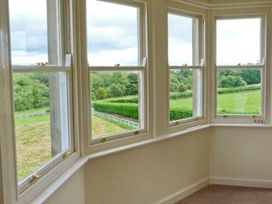 A room with windows showing a view of green fields at Priory View in Ulverston