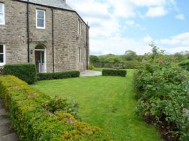 A garden with a stone wall and pathway at Priory View in Ulverston