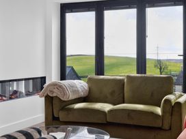 A living room with a sofa and a fireplace at Heddfan in Carmarthen