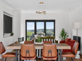 A dining room with a table and chairs at Heddfan in Carmarthen