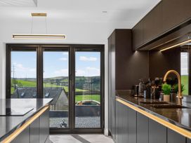 A kitchen with a view of hills and a car outside at Heddfan Carmarthen