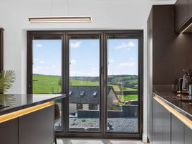 A kitchen with a window overlooking the countryside at Heddfan in Carmarthen