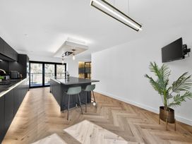 A kitchen with an island and bar stools at Heddfan in Carmarthen