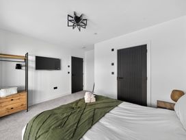 A bedroom with a bed and a television at Heddfan in Carmarthen