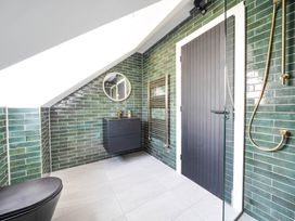 A bathroom with a shower and mirror at Heddfan in Carmarthen