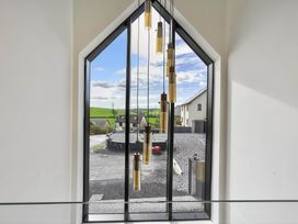 A window with light fixtures showing an outdoor view at Heddfan in Carmarthen