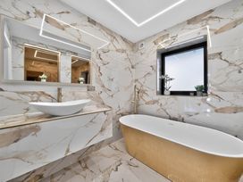 A bathroom with a bathtub and sink at Heddfan in Carmarthen