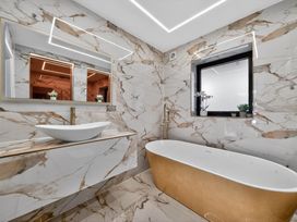 A bathroom with a bathtub and sink at Heddfan in Carmarthen