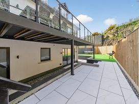 An outdoor area with patio, grass and seating at Heddfan in Carmarthen