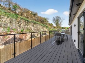 An outdoor deck with a table and chairs at Heddfan in Carmarthen